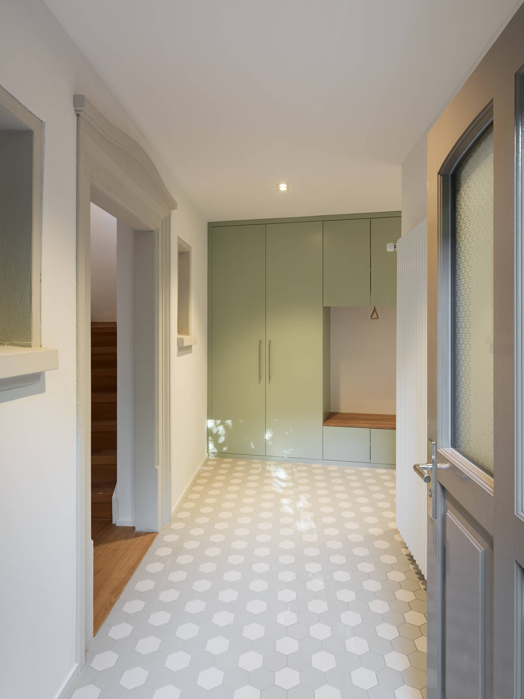 arba_gernstrasse_garderobe.jpg Neuer Eingangsbereich im Anbau mit historischer Steinfassung der ehemaligen Eingangstüre.